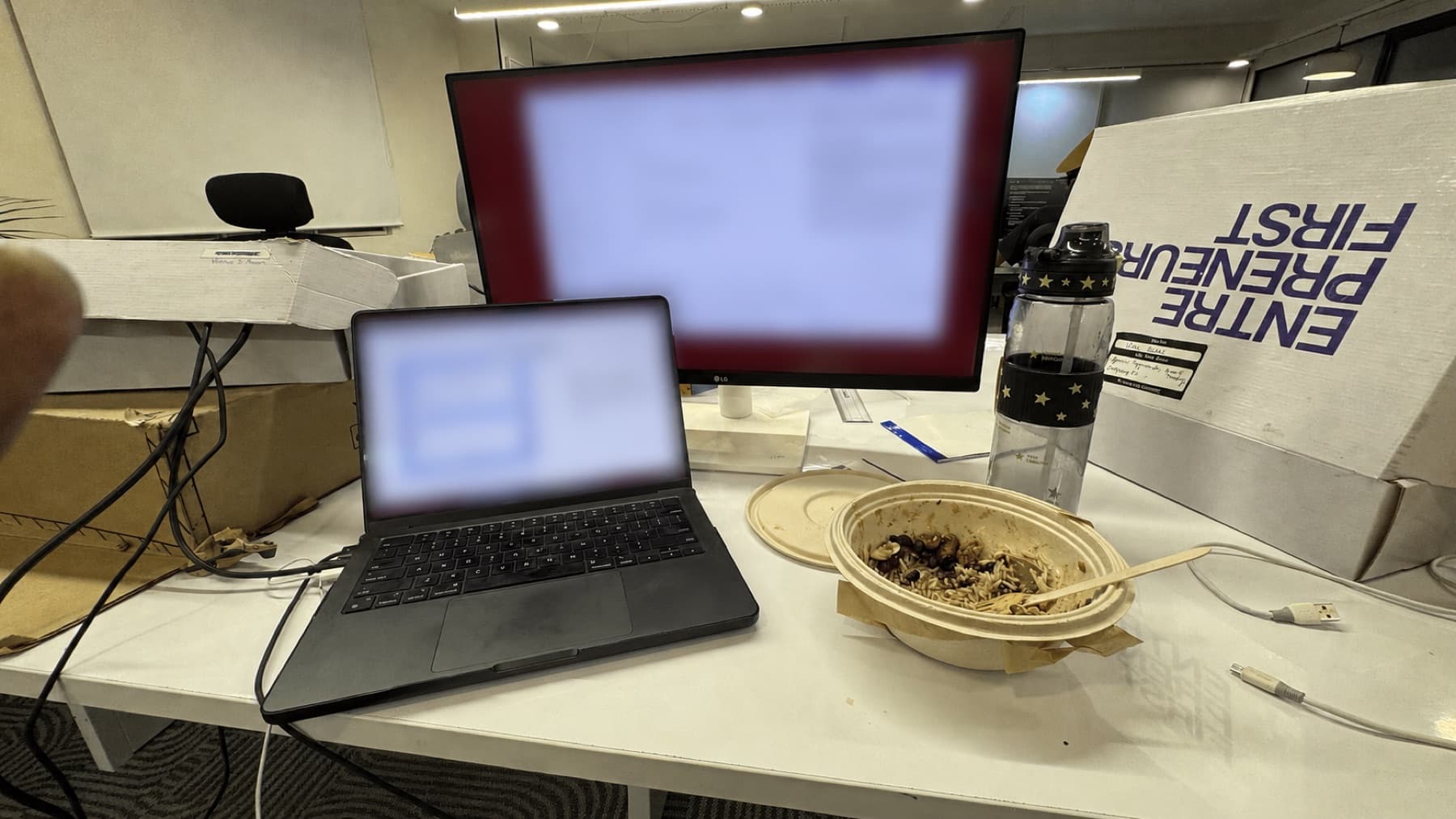 a laptop and monitor at a busy work desk